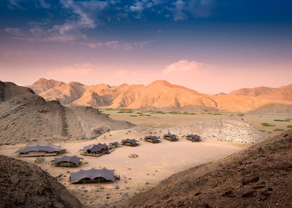 Hoanib Valley image taken from above showing the desert landscape and the safari tents at dusk.