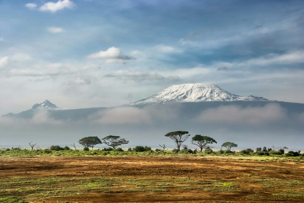 Kenya: A stunning landscape showcasing the majestic peak of Mount Kilimanjaro, surrounded by the vast plains and natural beauty of the region.