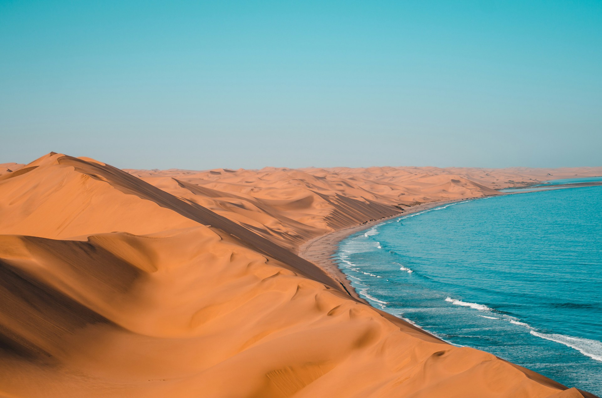 Namibia Desert Coast: A stunning aerial view of the desert coastline and pristine beach with vibrant blue sea, showcasing the natural beauty of Namibia's coastline.