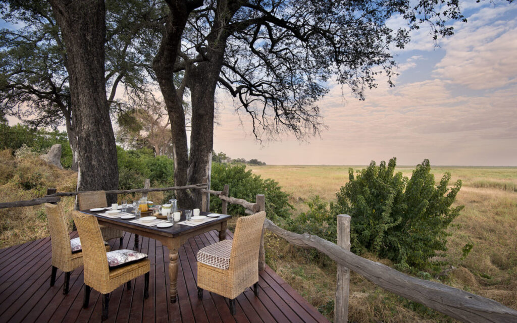 Beautiful sunset view from the deck at Linyanti showing a table and chairs ready for guests