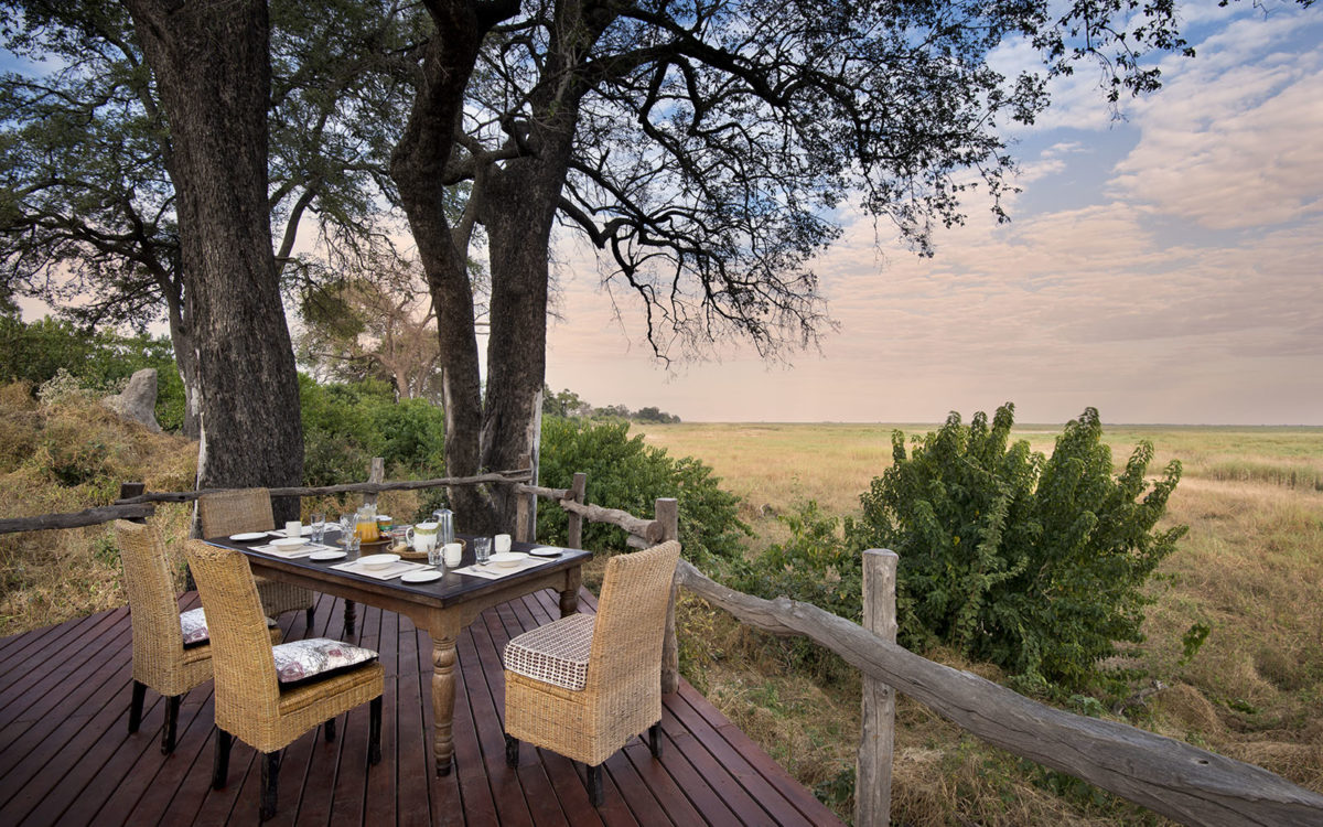 Beautiful sunset view from the deck at Linyanti showing a table and chairs ready for guests