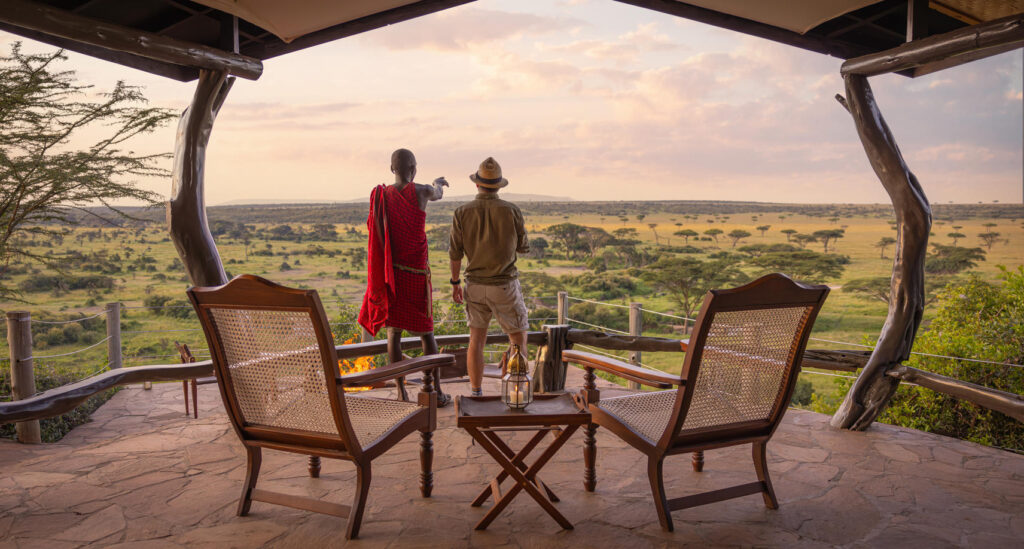 Masai and guest overlooking the plains in the Mara Conservancy