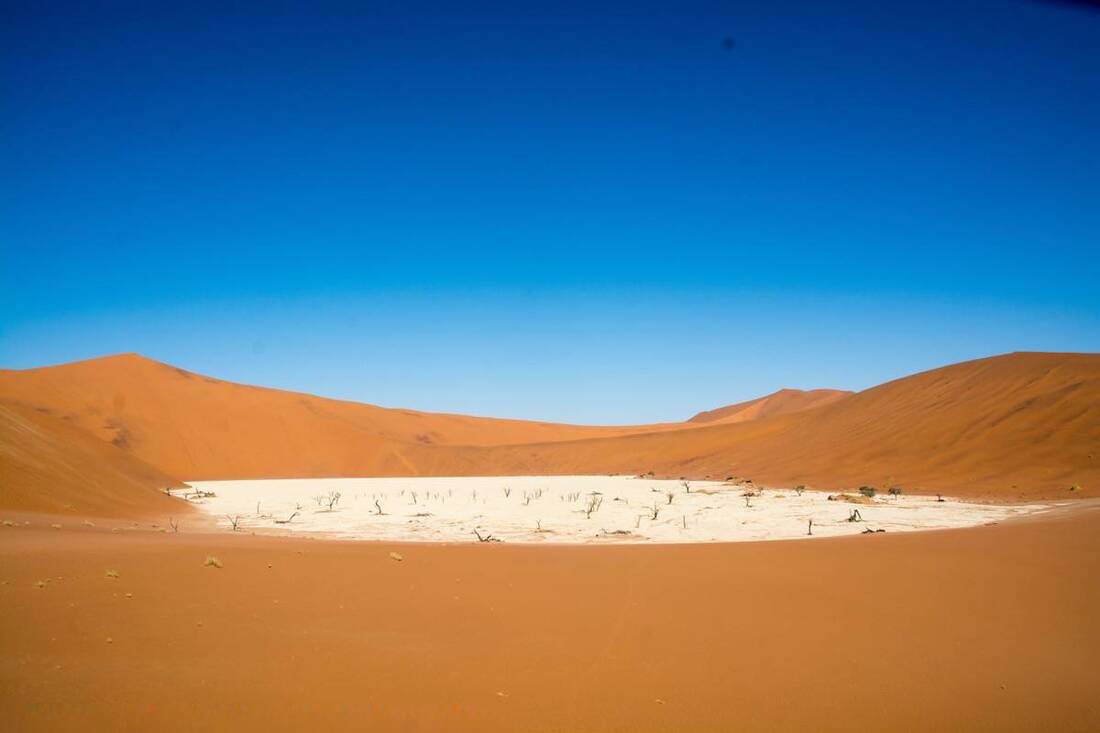 Red Sand Dunes surrounding white sand bank in Sossusvlei
