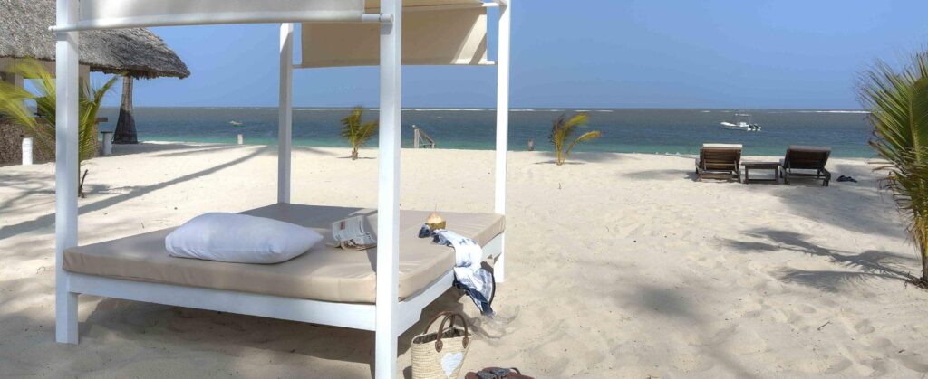 Malindi Beach views, sunbed with white sands and some vegetation.