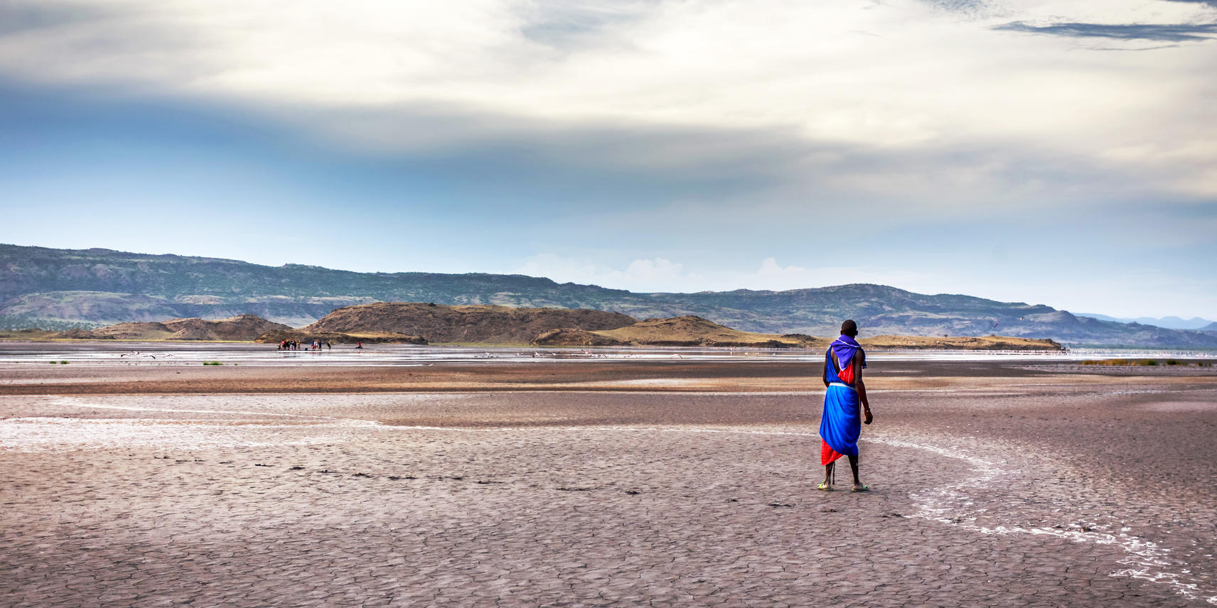 Local person standing in the space-like plains of Lake Natron