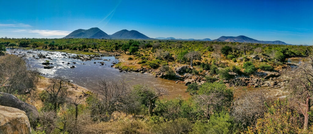 Stunning elevated view of the river with a small hill in the back ground and greenery on the river banks