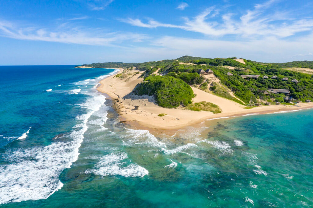 Aerial View of the point of Maputo, showing the tropical setting of land surrounded by the turquoise waters so clean you can see the reef below.