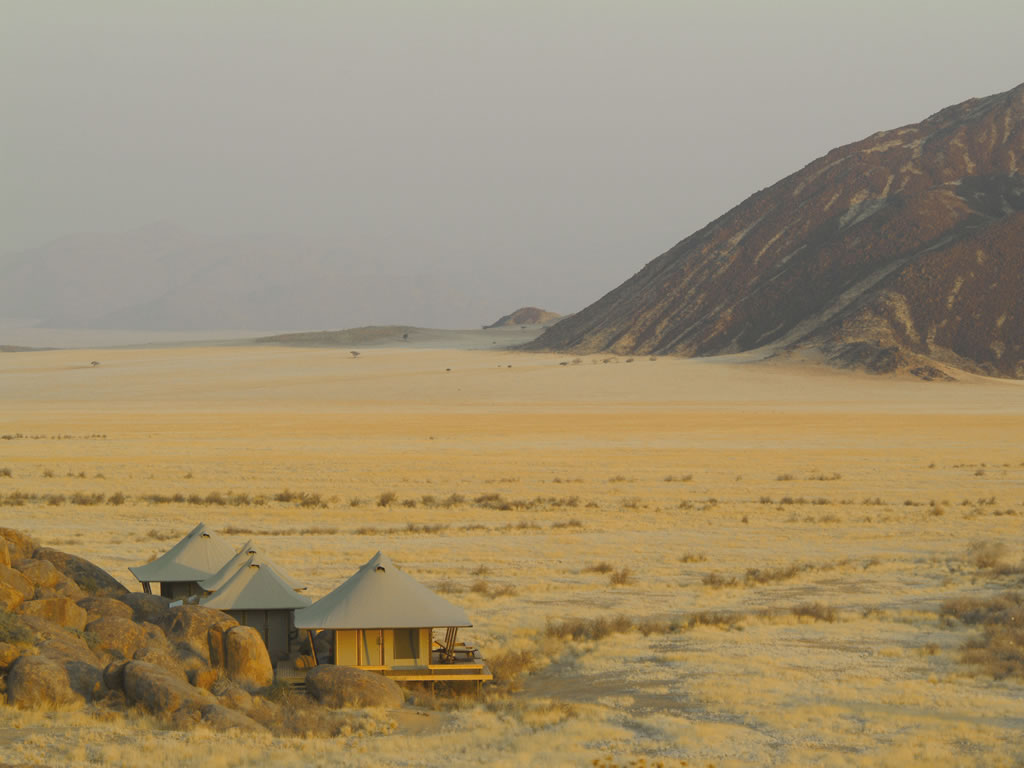 Aerial view of accommodation in the vastness of NamibRand a mountain in the background