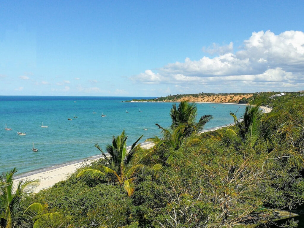 Image from height of the beach and turquoise blue waters - some boats in the bay.