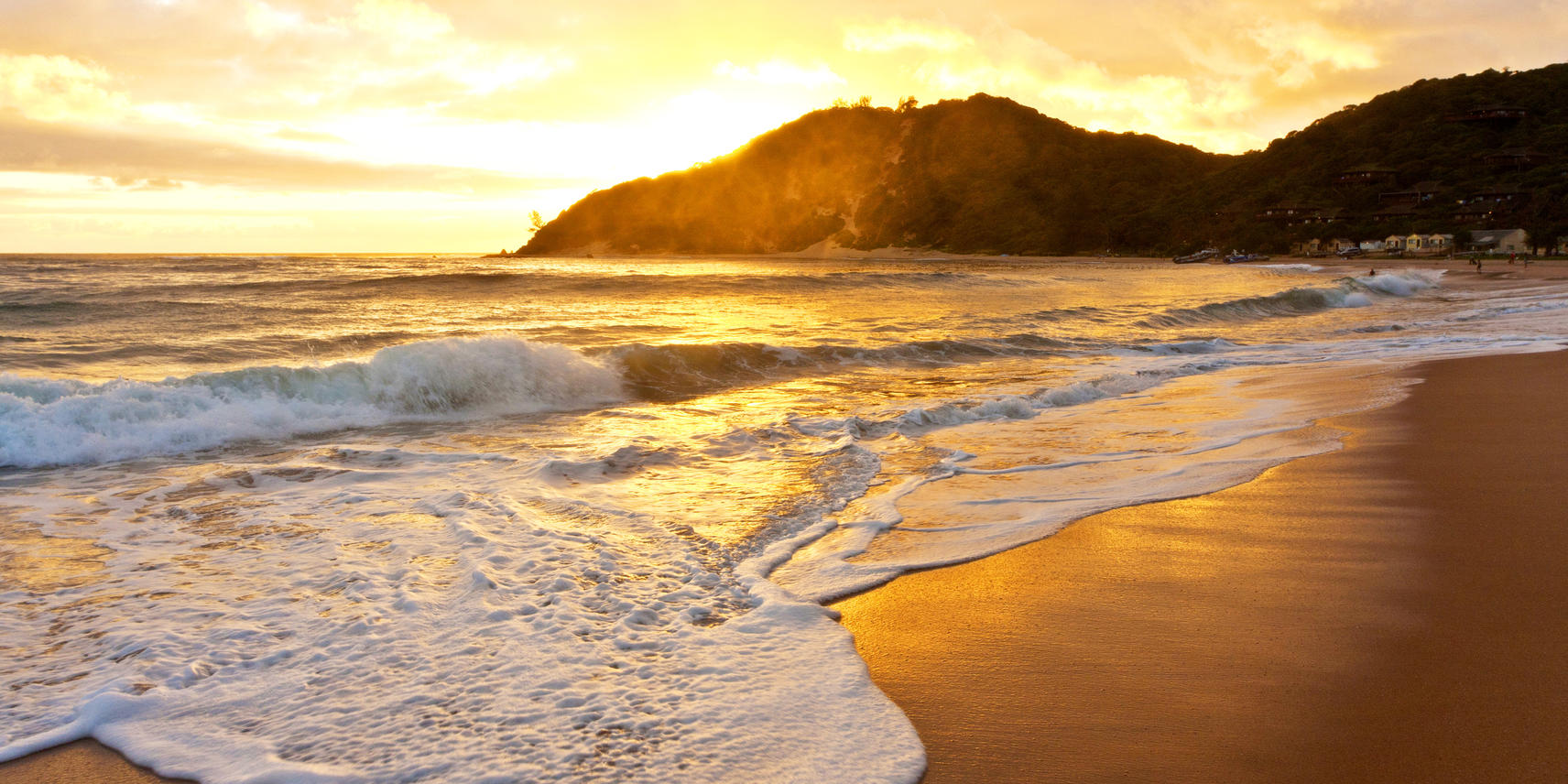 Sunset at Ponta Mamoli by Ponta Do Ouro with one of the Sand Dunes obscuring the sun while waves crash on the beach.
